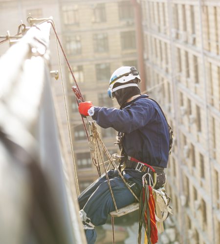 Industrial climber lowering from a roof of a building